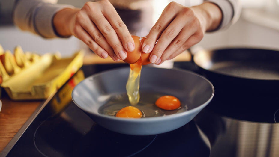 Close up of woman cooking eggs Close up of woman cooking eggs