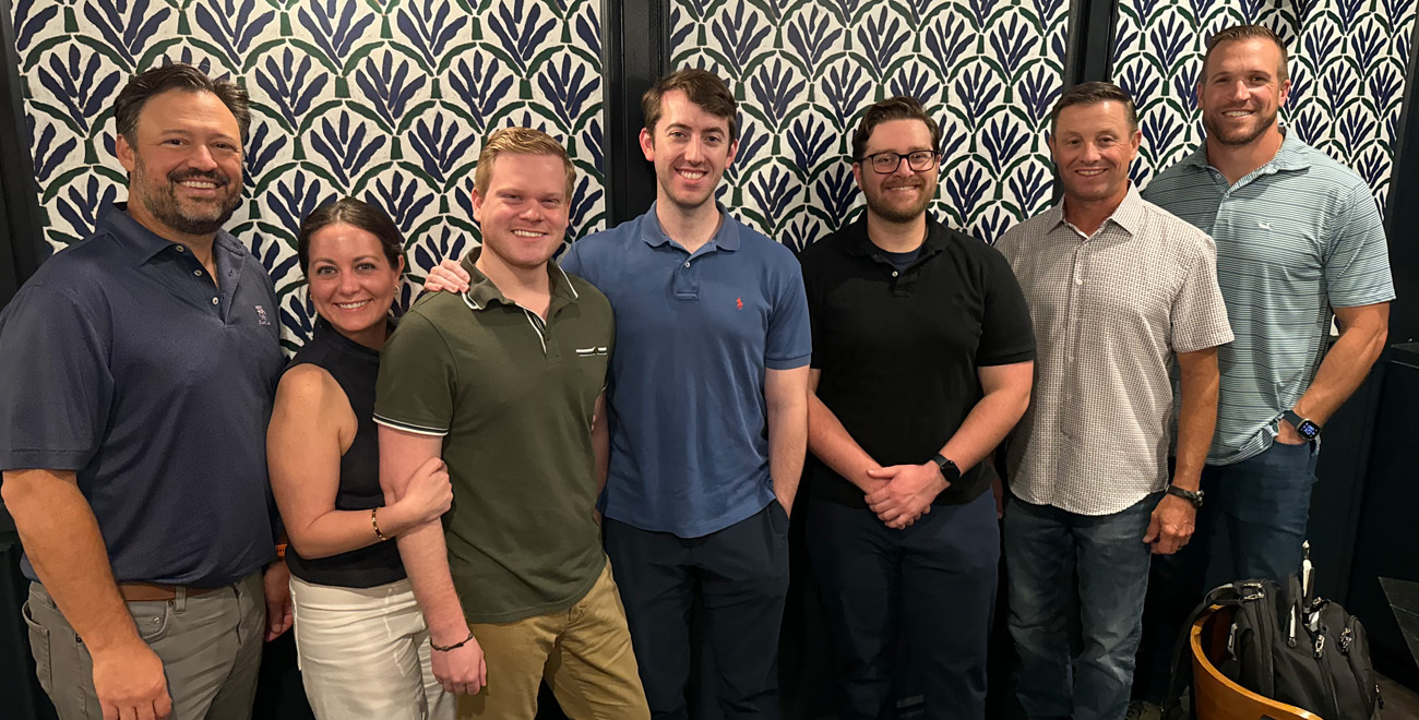 Group of Ochsner general surgery housestaff and physicians posing together indoors against a patterned wall.