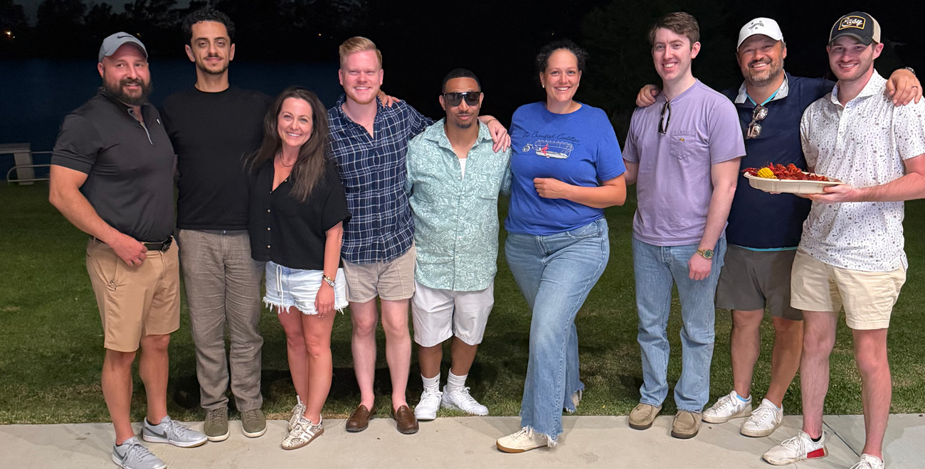 Group of Ochsner general surgery housestaff and residents gathered outside at night, with one holding a plate of crawfish.