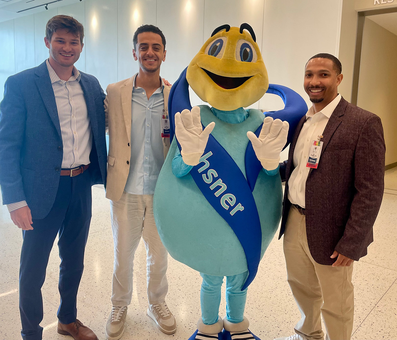 Surgical residents and faculty pose together with the Ochsner Lifemark mascot