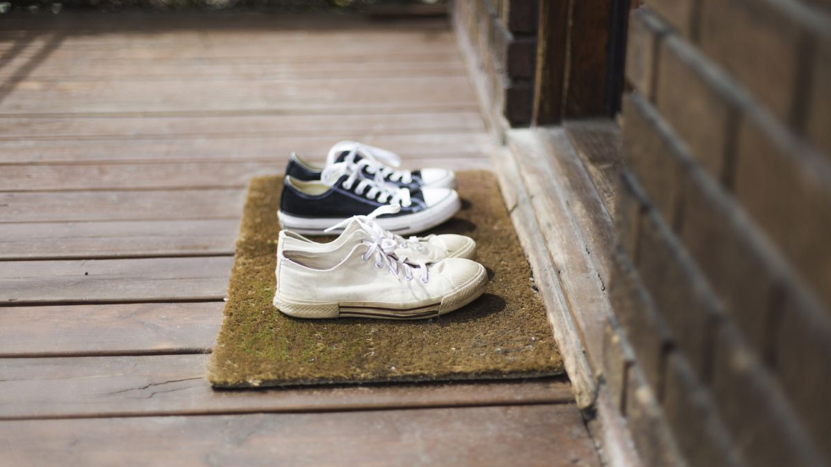 Two pairs of shoes left outside on porch