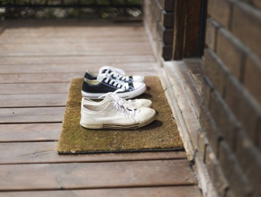 Two pairs of shoes left outside on porch