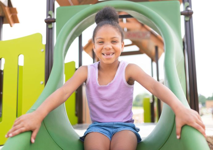 Little girl playing on slide
