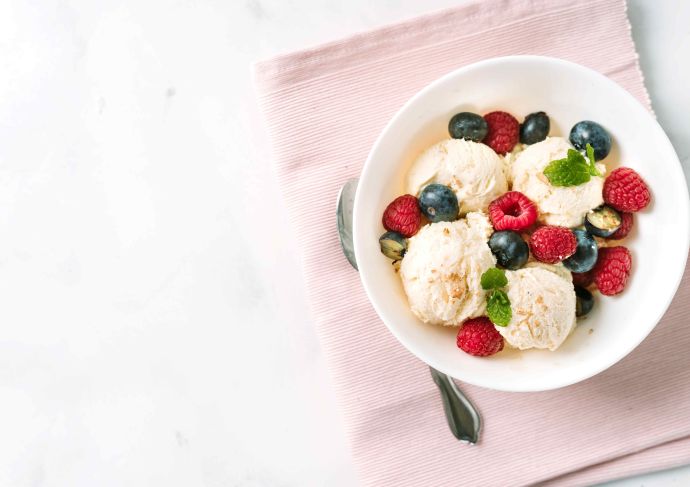 Scoops of vanilla ice cream in a bowl with berries