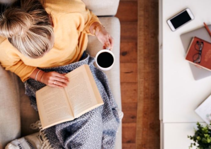 Woman sitting on coach with coffee