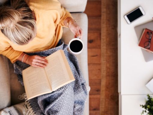 Woman sitting on coach with coffee