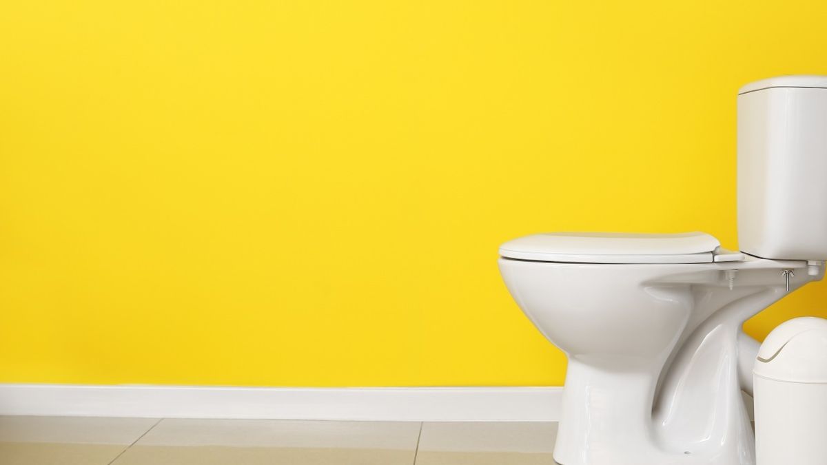 White toliet with yellow background