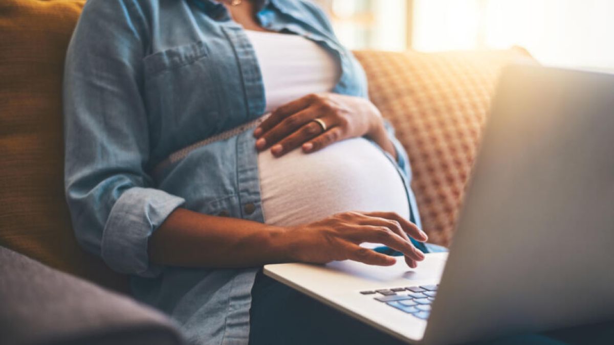 Pregnant woman on computer virtual classes mom