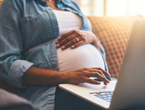 Pregnant woman on computer virtual classes mom
