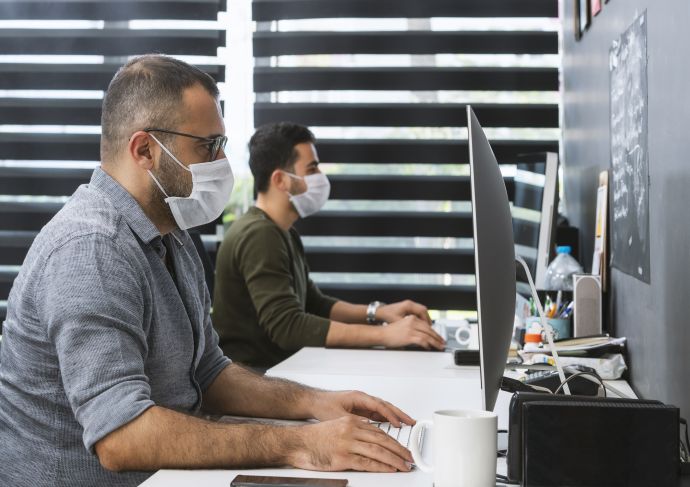 People working at computers with masks