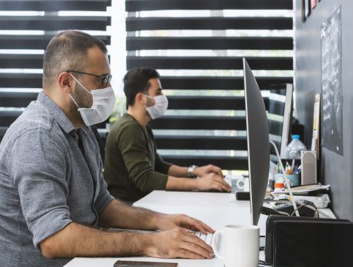 People working at computers with masks