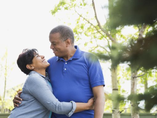 Husband and wife smiling at each other outside on a walk