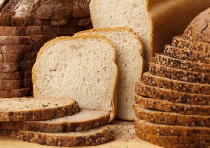 Various types of bread, sliced up on a table