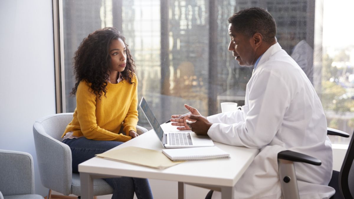 Woman talking with her doctor at his desk