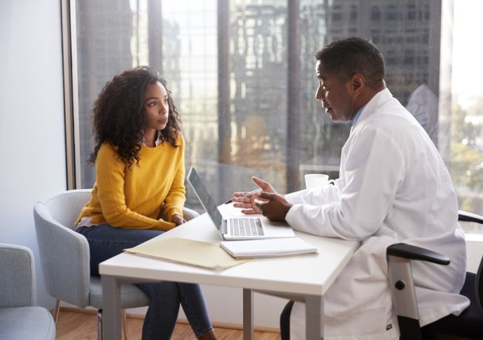 Woman talking with her doctor at his desk