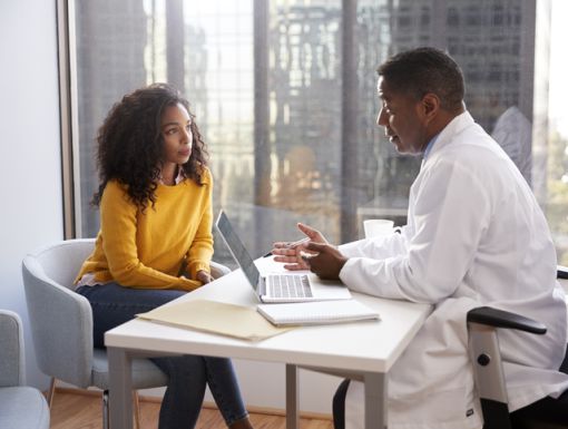 Woman talking with her doctor at his desk