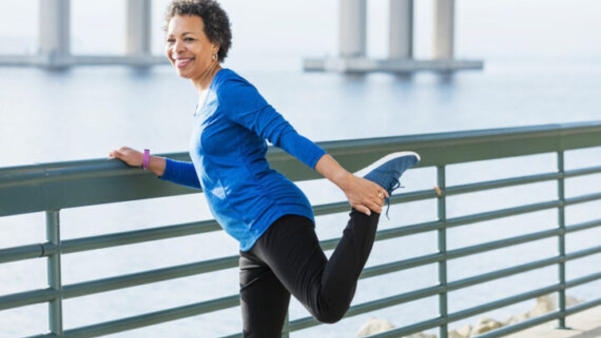Older woman stretching joints outside before a workout