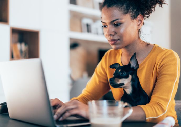 Woman looking at her computer with her dog