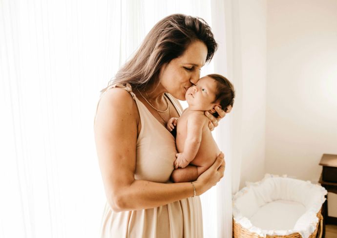 Woman who wants a tummy tuck holding newborn