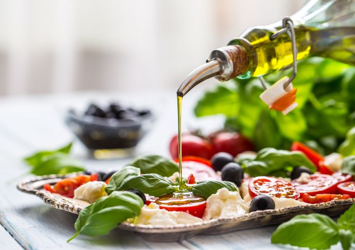 Pouring olive oil on salad