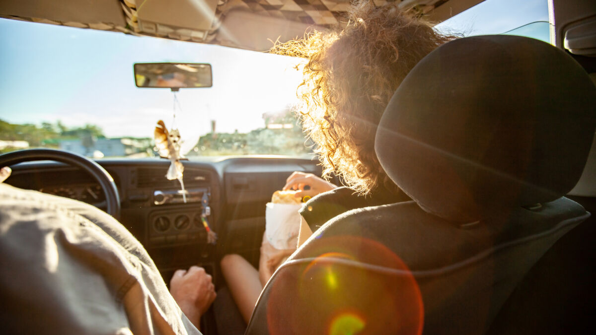 Woman snacking in car on roadtrip