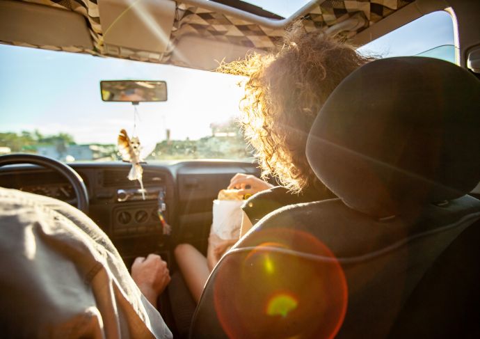 Woman snacking in car on roadtrip