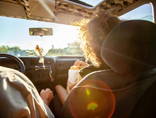 Woman snacking in car on roadtrip
