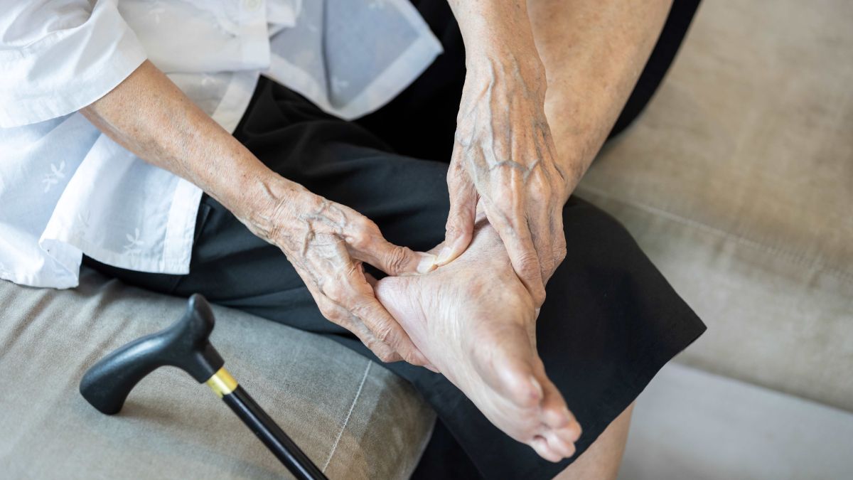Woman with tendonitis gripping foot