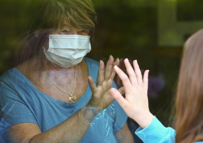 Older woman through glass immunocompromised