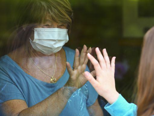 Older woman through glass immunocompromised