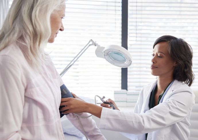 Older woman getting her blood pressure checked by her doctor