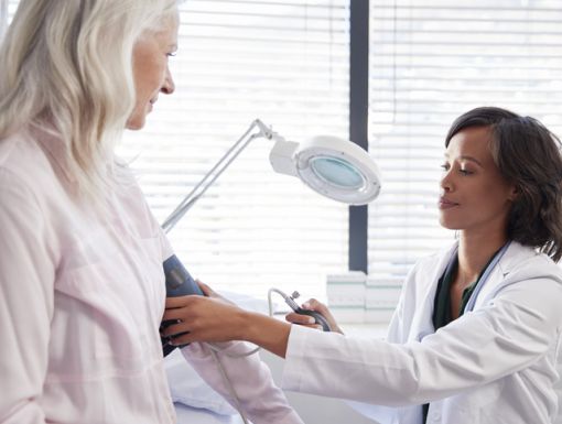 Older woman getting her blood pressure checked by her doctor