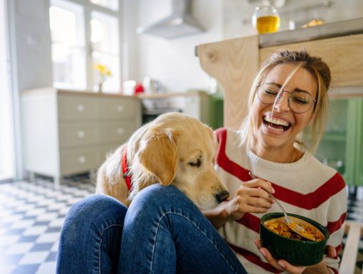 Girl eating cereal with dog