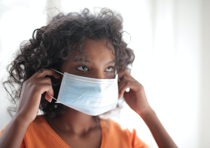 Woman putting on face mask