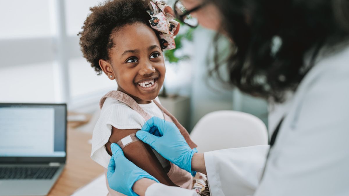 Young girl smiling while getting vaccine