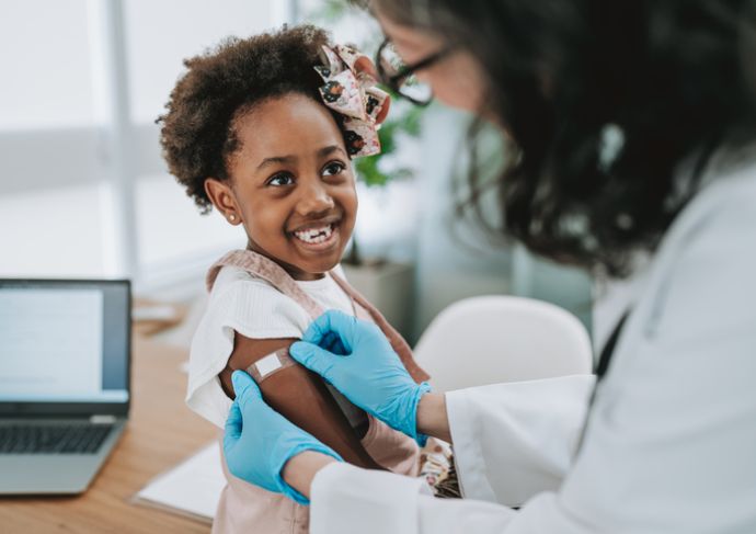 Young girl smiling while getting vaccine