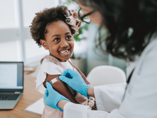 Young girl smiling while getting vaccine