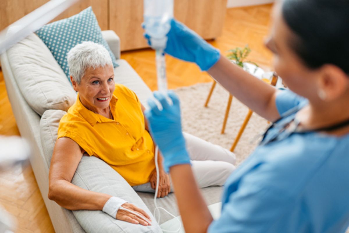 Patient receiving IV infusion therapy from a nurse