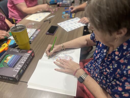 Woman coloring in coloring book at a table