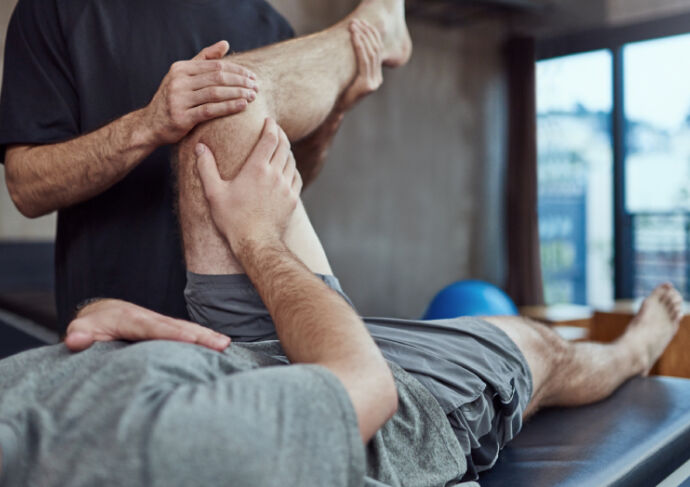 Athlete on a table getting their knee stretched