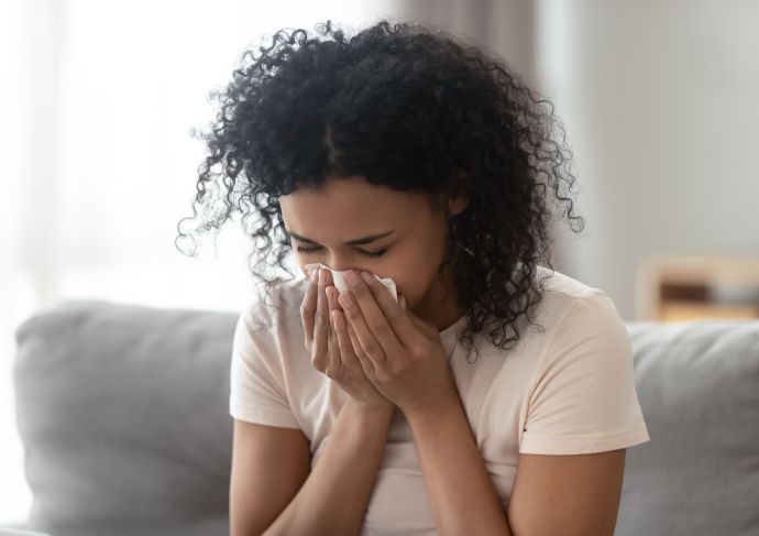 Woman with allergies blowing nose