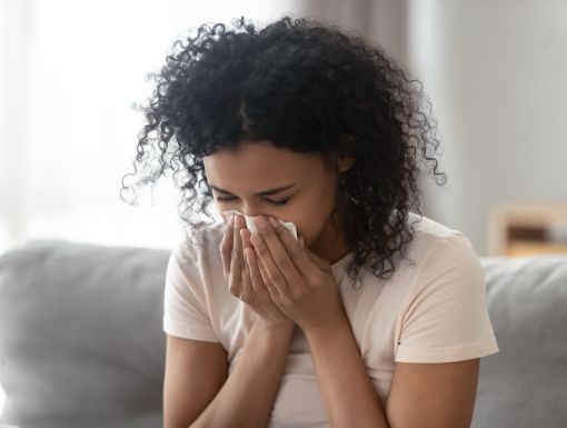 Woman with allergies blowing nose