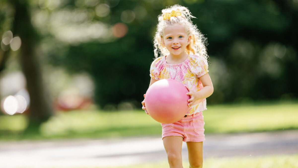 Tilly playing outdoors with a pink ball