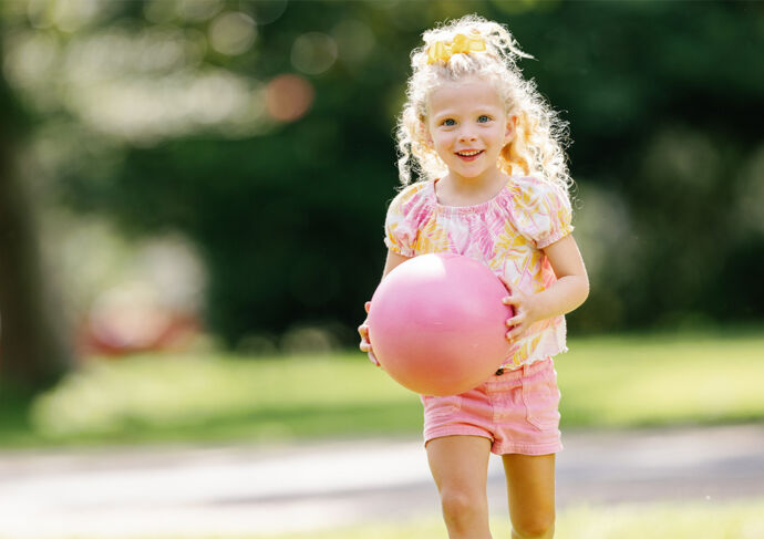 Tilly playing outside with a pink ball