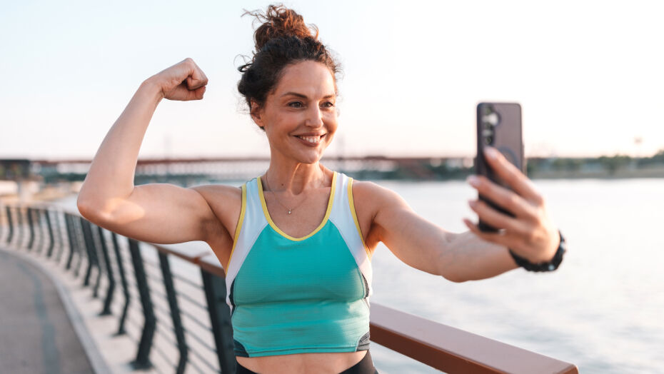 Woman taking a selfie while flexing her bicep