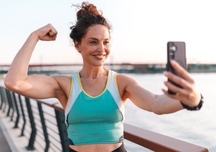 Woman taking a selfie while flexing her bicep