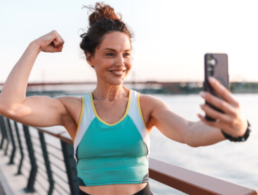 Woman taking a selfie while flexing her bicep
