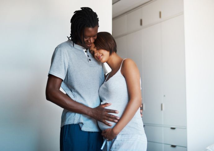 Expting mom and partner holding her belly