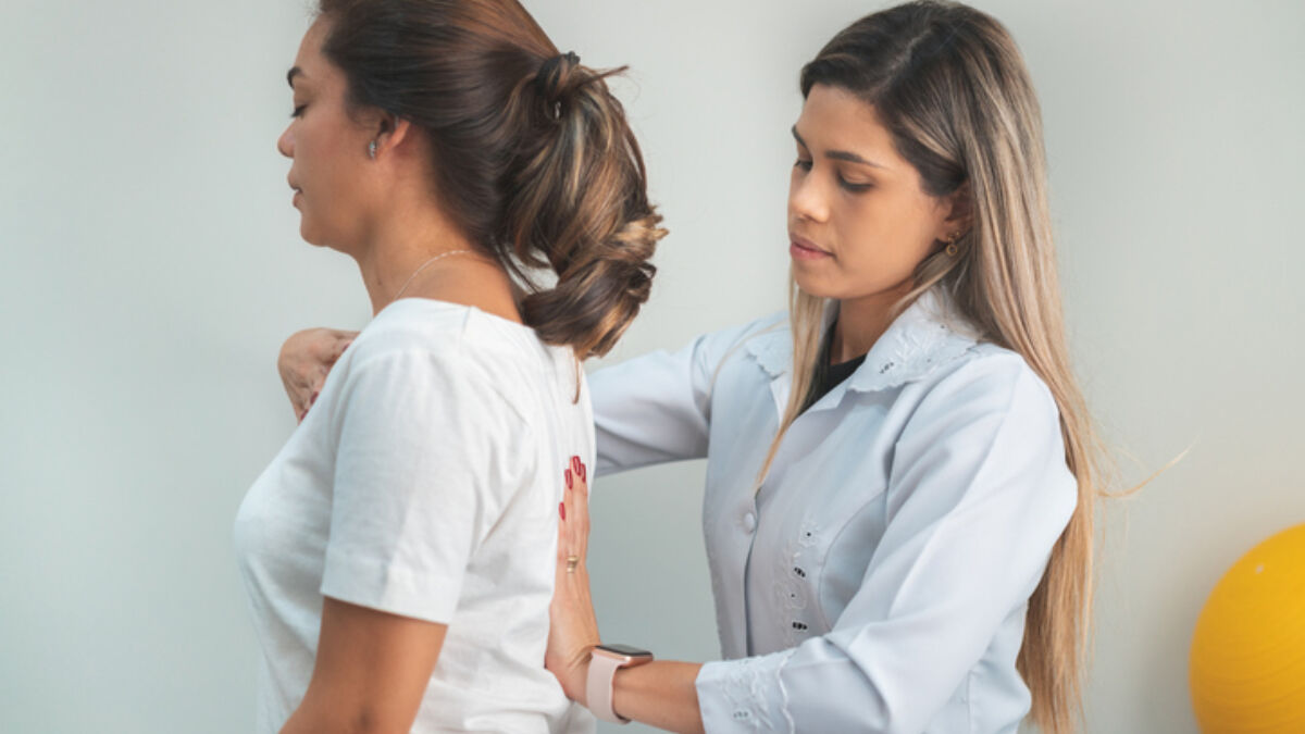 Woman standing while a doctor improves her posture