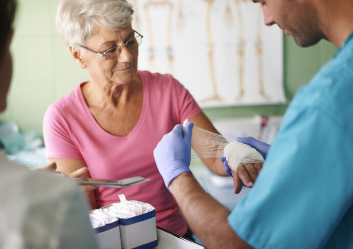 Woman getting a wound on her hand dressed